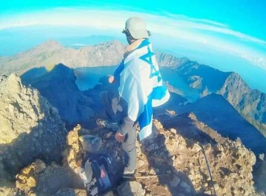 سائح إسرائيلي يرفع علم الكيان الصهيوني في جزيرة سقطرى اليمنية